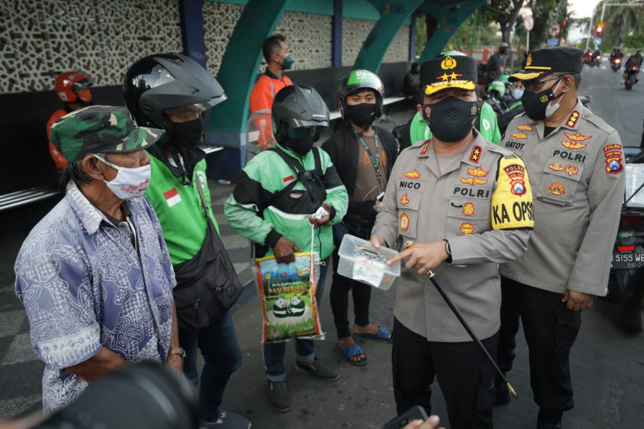 Kapolda Jatim Bagikan Beras dan Kenakan Masker Pada Anak Kecil yang Tak Kenakan Masker